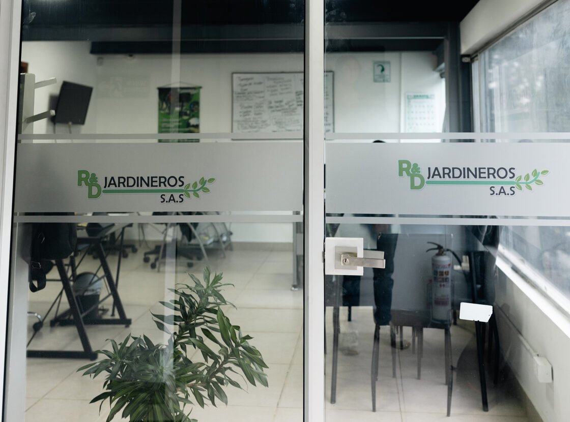 Vista general de la oficina de RYD con el logo de la empresa en las mamparas de vidrio