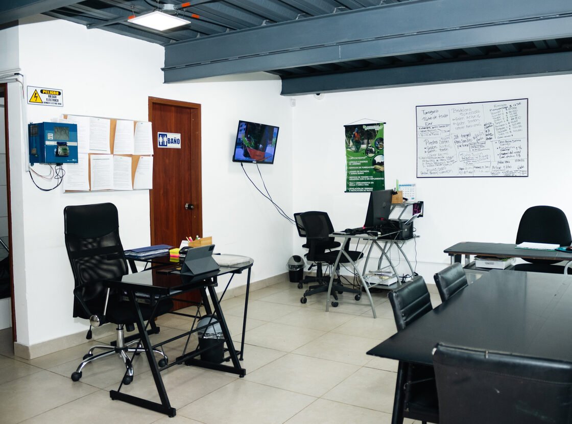 Sala de reuniones de la oficina de RYD con escritorios, sillas y tablero de planeación