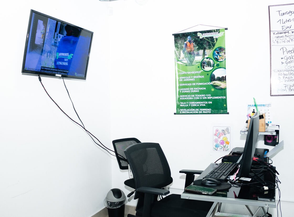 Puesto de trabajo de la oficina de RYD con pendón de servicios y tablero de programación