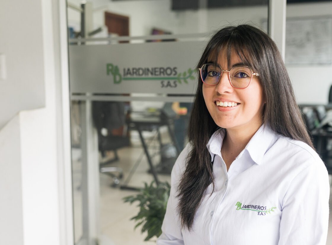 Auxiliar administrativa de RYD en la oficina, con el logo de la empresa en el vidrio detrás