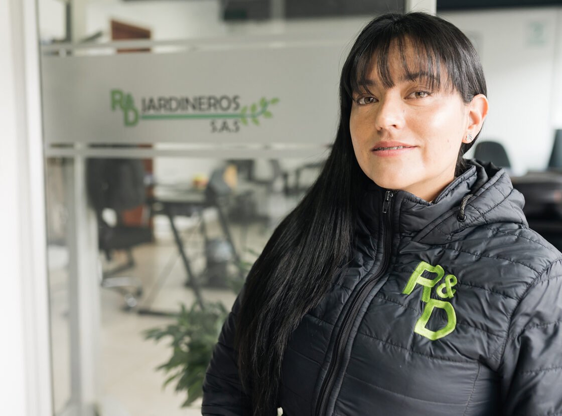 Integrante del equipo administrativo de RYD con chaqueta de la empresa, en la oficina