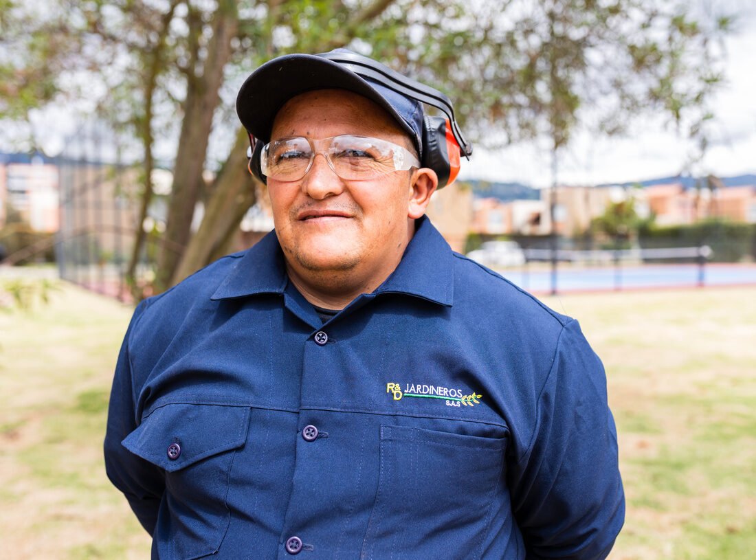 Retrato de un jardinero de RYD sonriendo, con gafas de seguridad y protección auditiva
