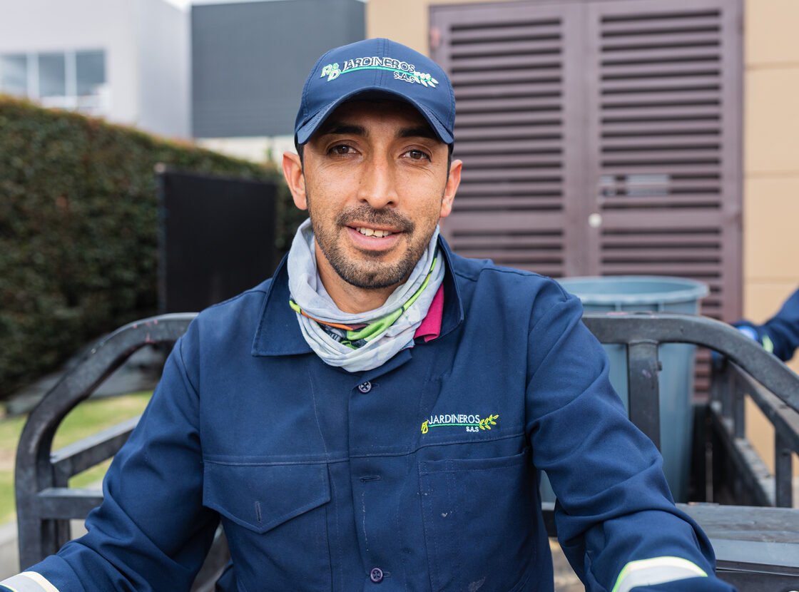 Operario de RYD sonriendo al volante del motocarro eléctrico de la empresa